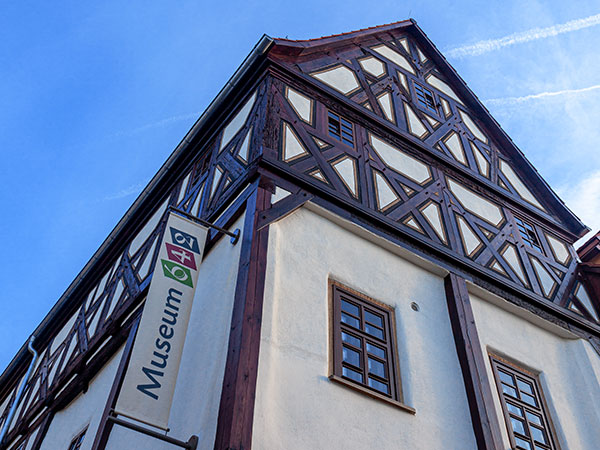 Fachwerkhaus mit Museumsschild „Museum642“ an der Fassade unter blauem Himmel.